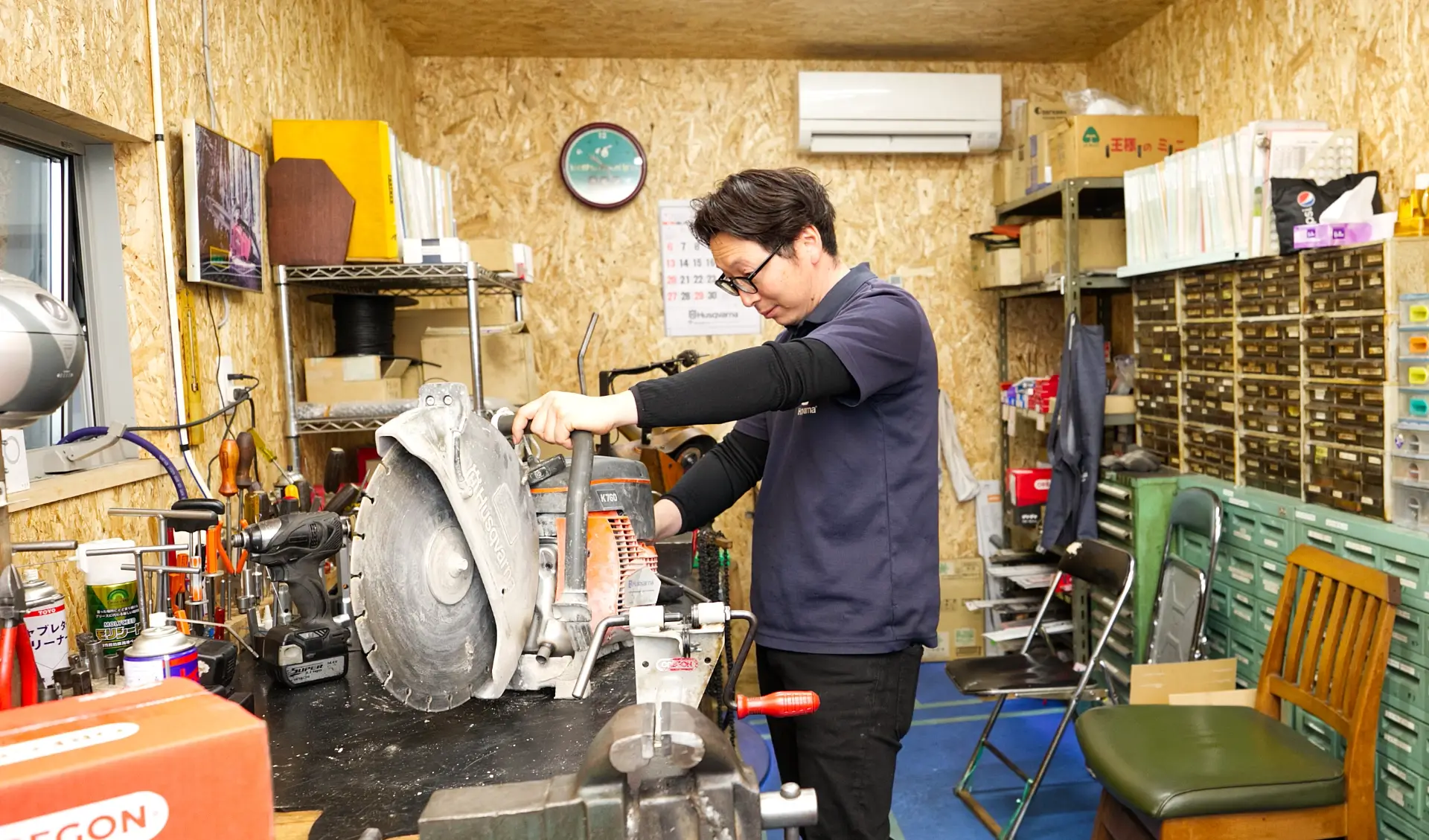 大型チェーンソーの修理作業を行うスタッフ